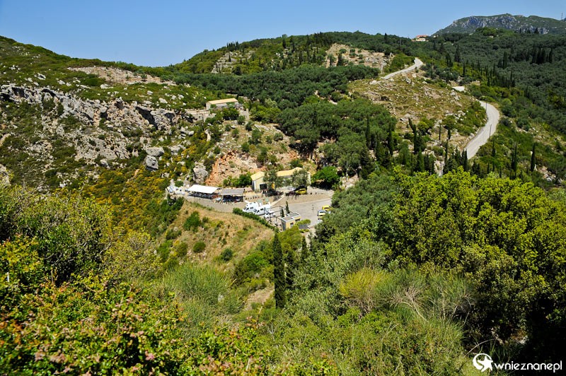 Grecka wyspa Korfu. Panorama okolic Paleokastritsy widziana z ruin zamku Angelokastro. W dole parking znajdujący się na początku drogi do ruin. - foto: wnieznane.pl Grecka wyspa Korfu. Panorama okolic Paleokastritsy widziana z ruin zamku Angelokastro. W dole parking znajdujący się na początku drogi do ruin. - foto: wnieznane.pl