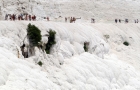 Pamukkale. Ludzie spacerujący po śnieżnobiałej skale przy trawertynach. - foto: wnieznane.pl
