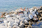 Cinque Terre. Ludzie plażujący na skałach w miejscowości Riomaggiore.  - foto: wnieznane.pl