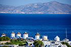 Mykonos. Słynne wiatraki w stolicy wyspy. W tle wyspa Tinos. - foto: wnieznane.pl