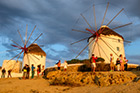 Mykonos. Wiatraki w stolicy wyspy w promieniach zachodzącego słońca. - foto: wnieznane.pl